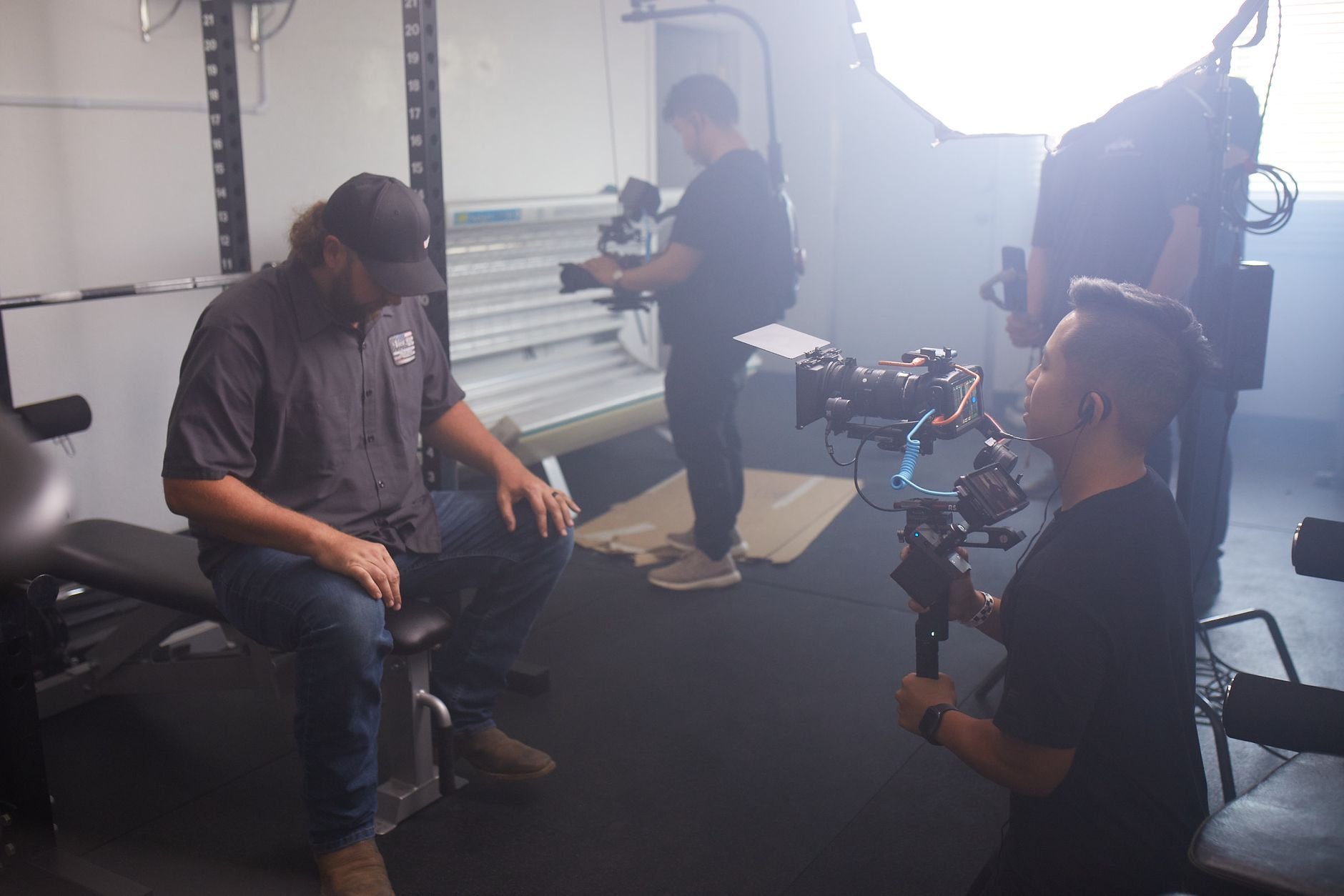 Behind-the-scenes of a video production session with crew and equipment in a modern studio setting.